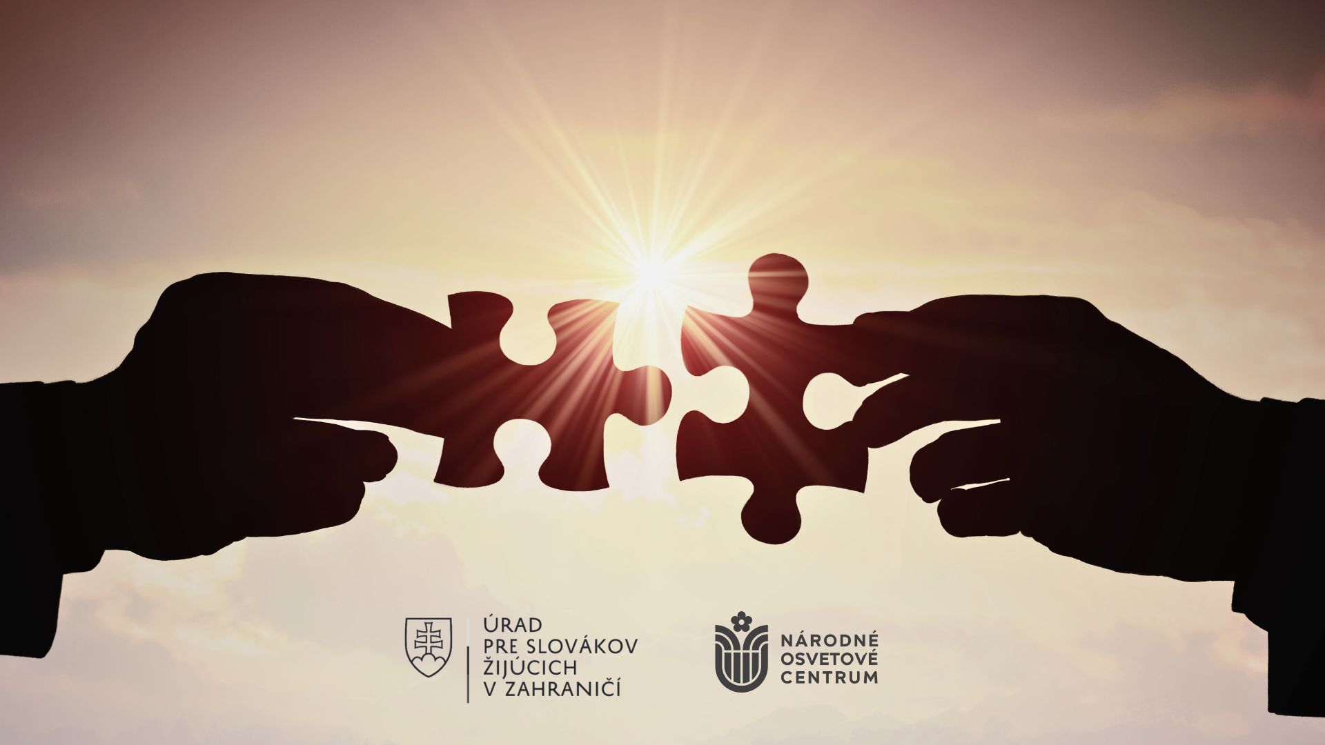ruky držiace puzzle, symbol spolupráce, v dolnej časti logá ÚSŽZ a NOC