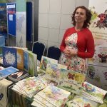 Jarmila Roser, prekladateľka a vydavateľka dvojjazyčnej detskej literatúry pri stánku s knihami