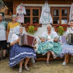 účasníci krajanského dvora, mnohí v krojoch, fotky zachytávajú neformálnu atmosféru