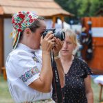 účasníci krajanského dvora, mnohí v krojoch, fotky zachytávajú neformálnu atmosféru