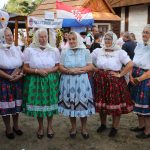 účasníci krajanského dvora, mnohí v krojoch, fotky zachytávajú neformálnu atmosféru