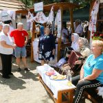 účasníci krajanského dvora, mnohí v krojoch, fotky zachytávajú neformálnu atmosféru
