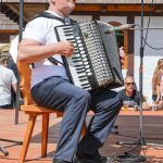 účasníci krajanského dvora, mnohí v krojoch, fotky zachytávajú neformálnu atmosféru