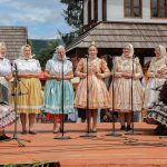 účasníci krajanského dvora, mnohí v krojoch, fotky zachytávajú neformálnu atmosféru