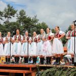 účasníci krajanského dvora, mnohí v krojoch, fotky zachytávajú neformálnu atmosféru